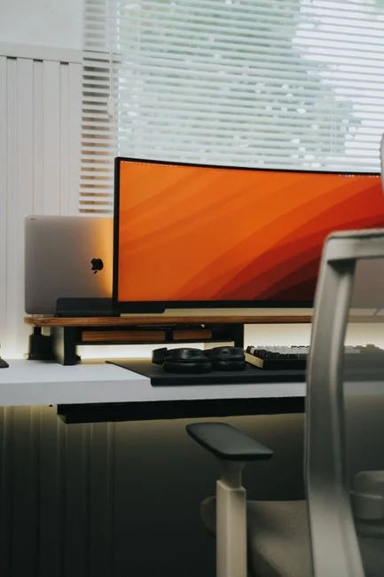 High-angle view of a stylish work desk featuring dual monitors, keyboard, mouse, and modern accessories.