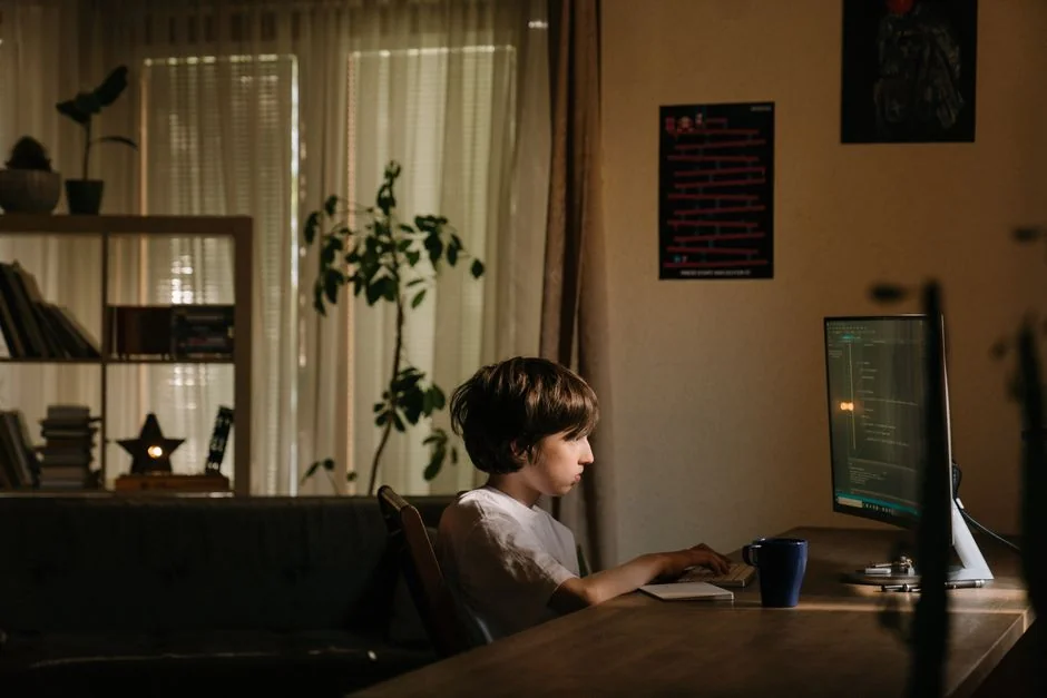 Man working on web design at home office setup with dual monitors.